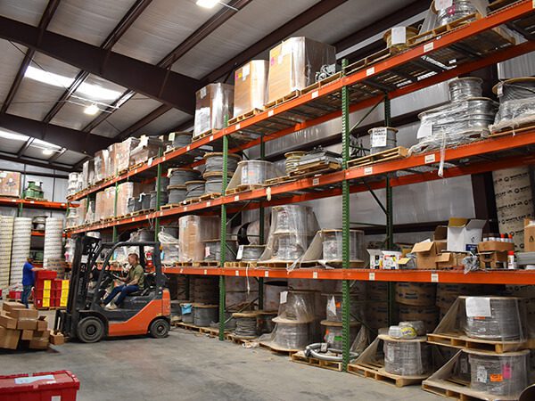 Prefab and warehouse at Fountain Electric & Services using lift to organize components and orders
