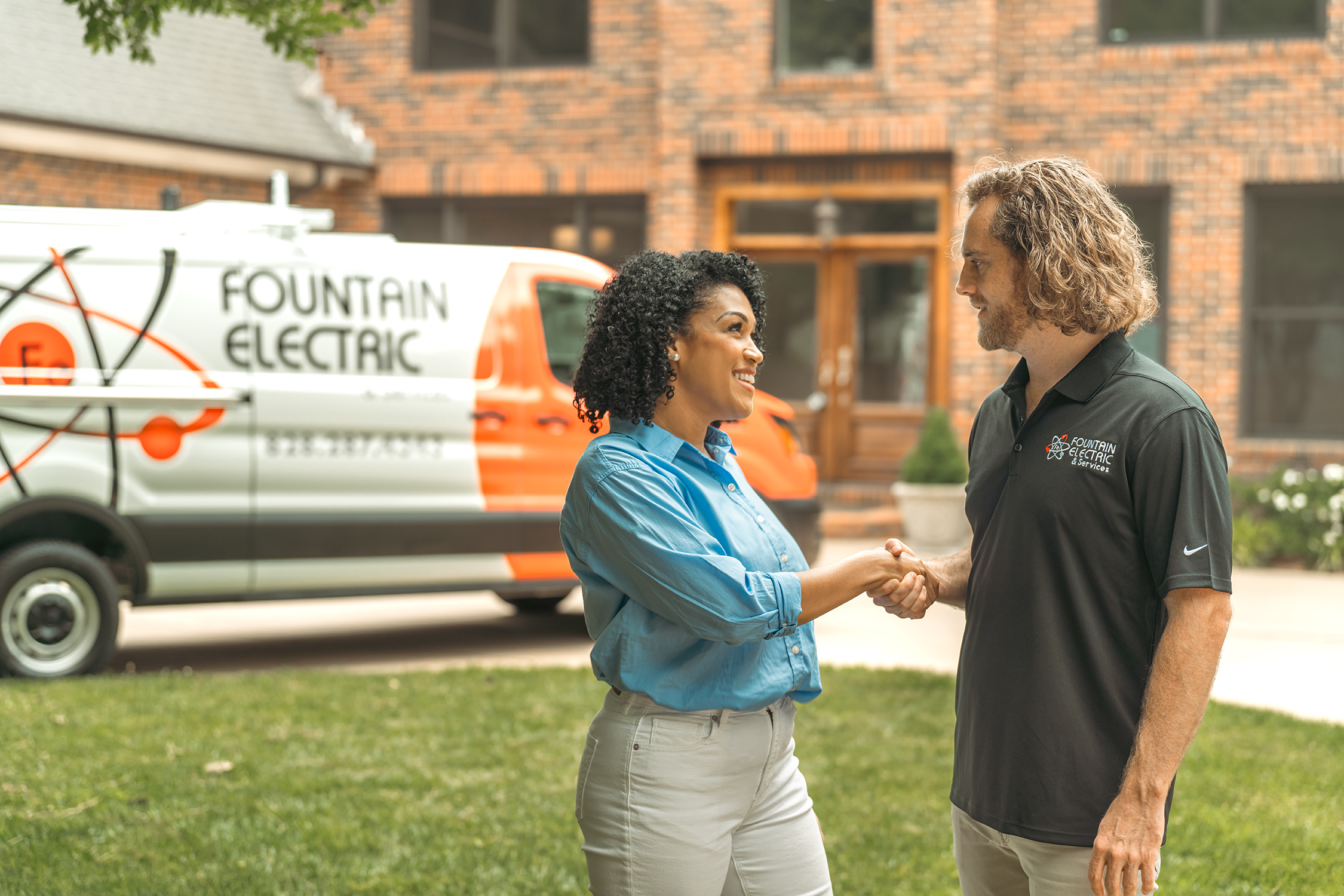 A Fountain Electric employee greeting a customer outside of her home.