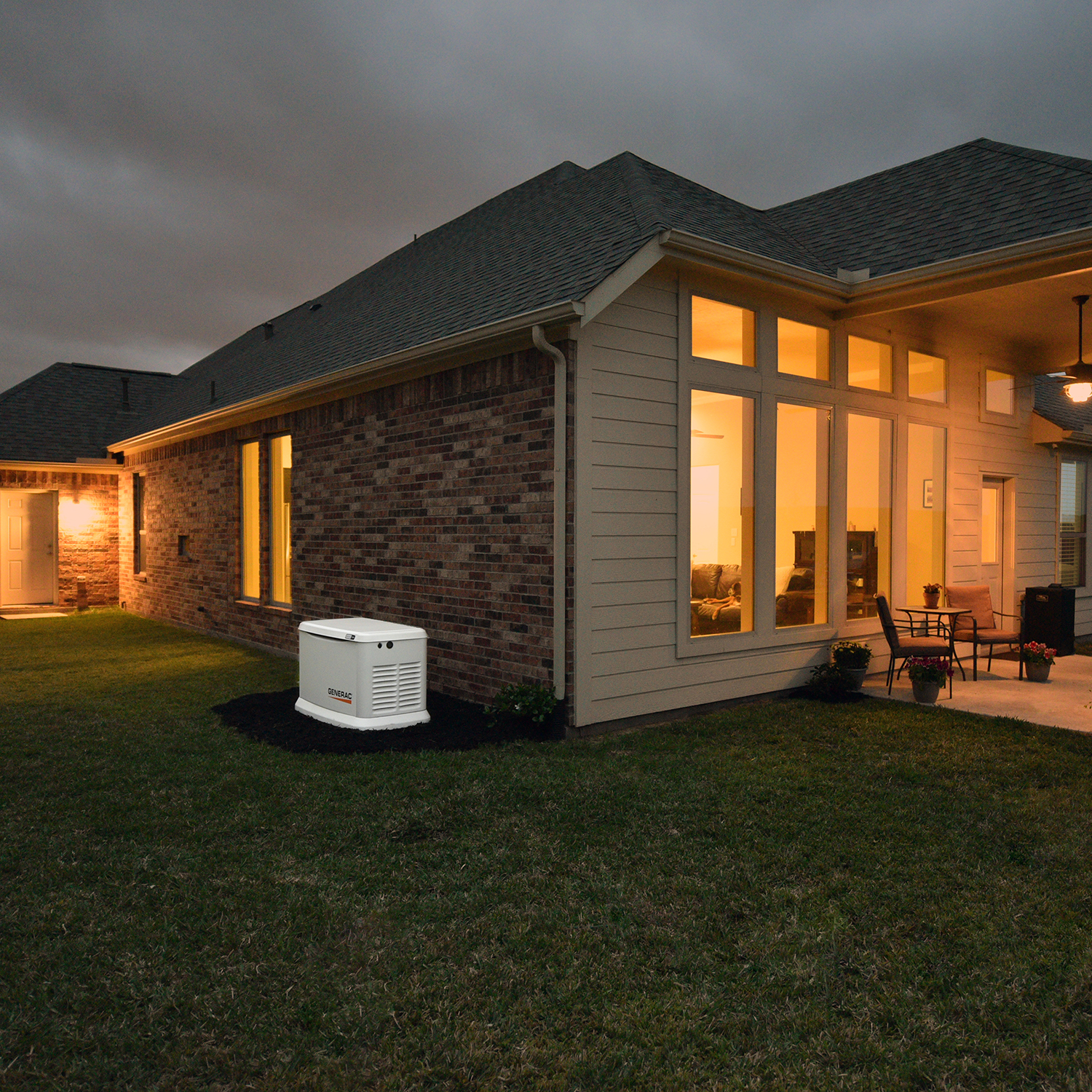 A Generac home standby generator outside of a home at night.