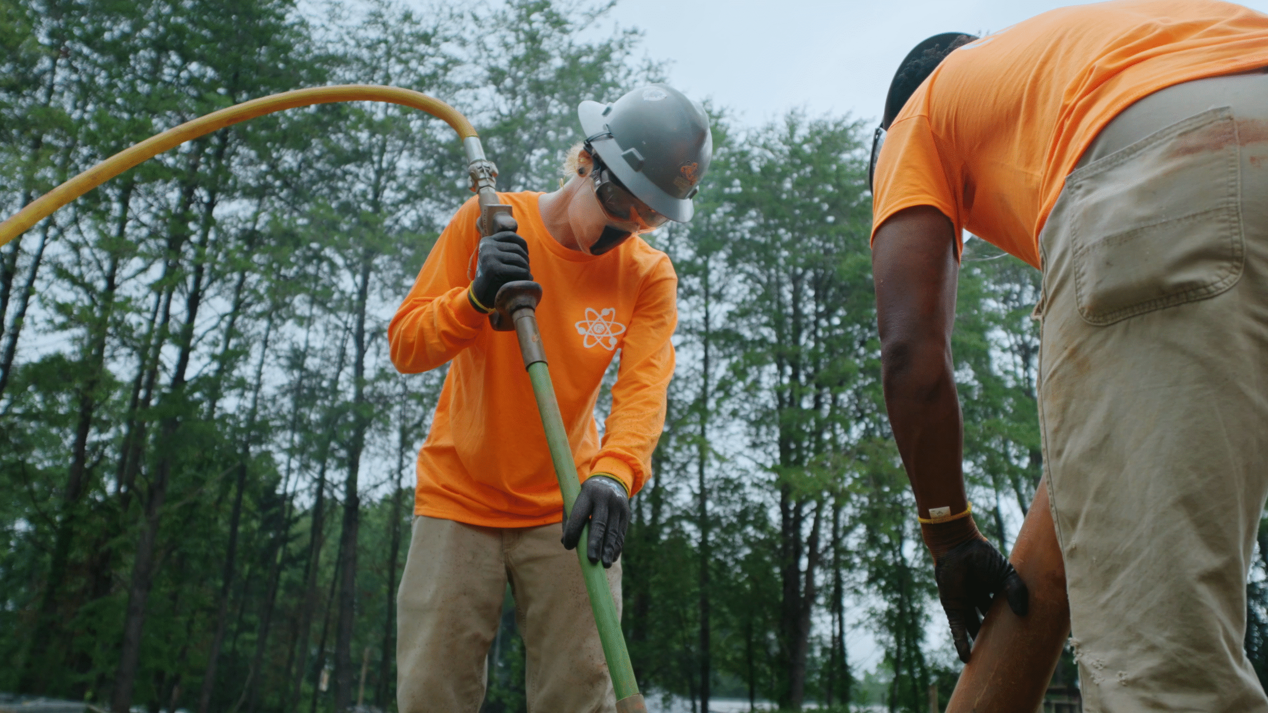 Workers use air excavation to dig a small trench.