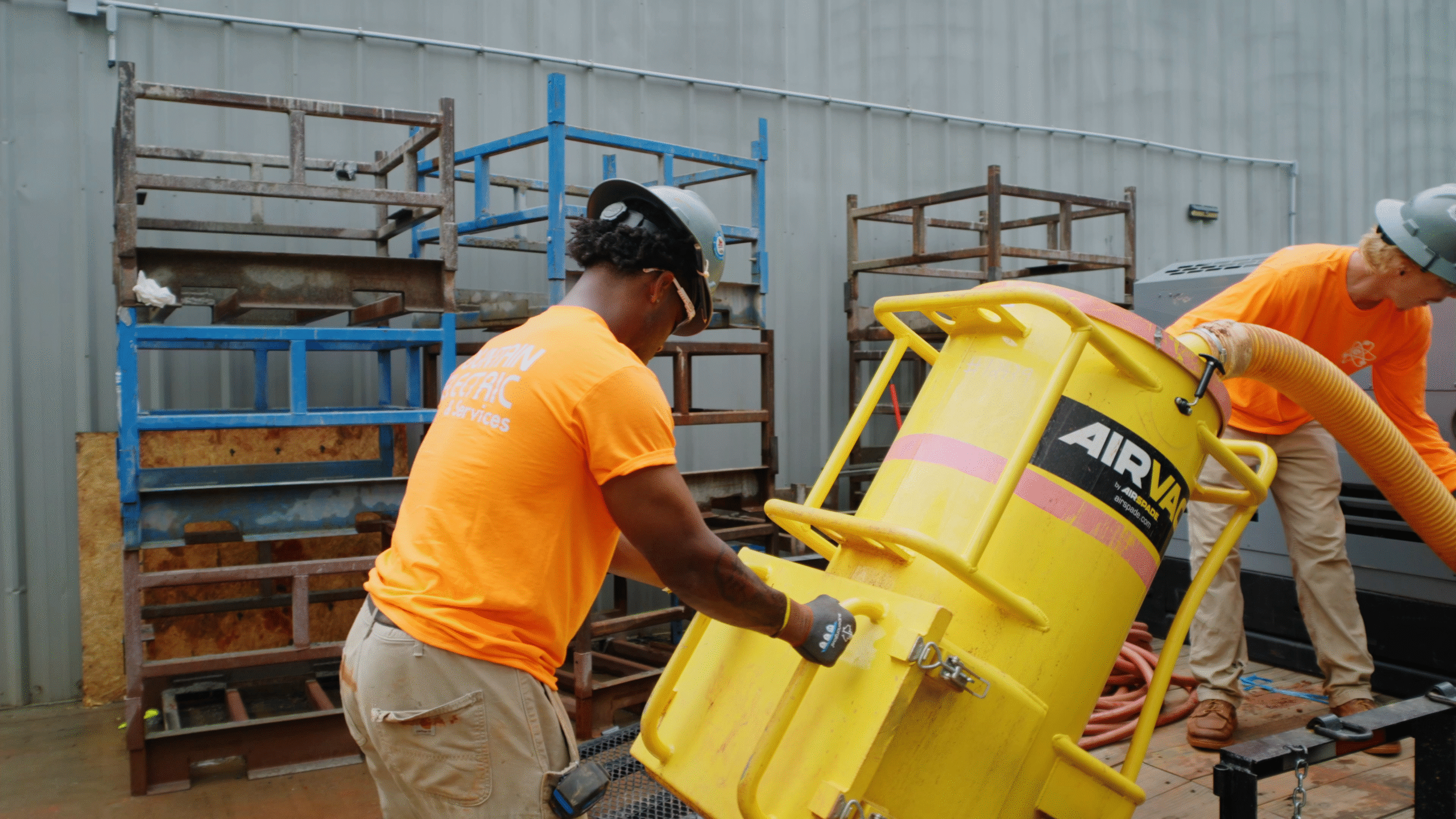 Workers move an air excavation unit onto the job site.