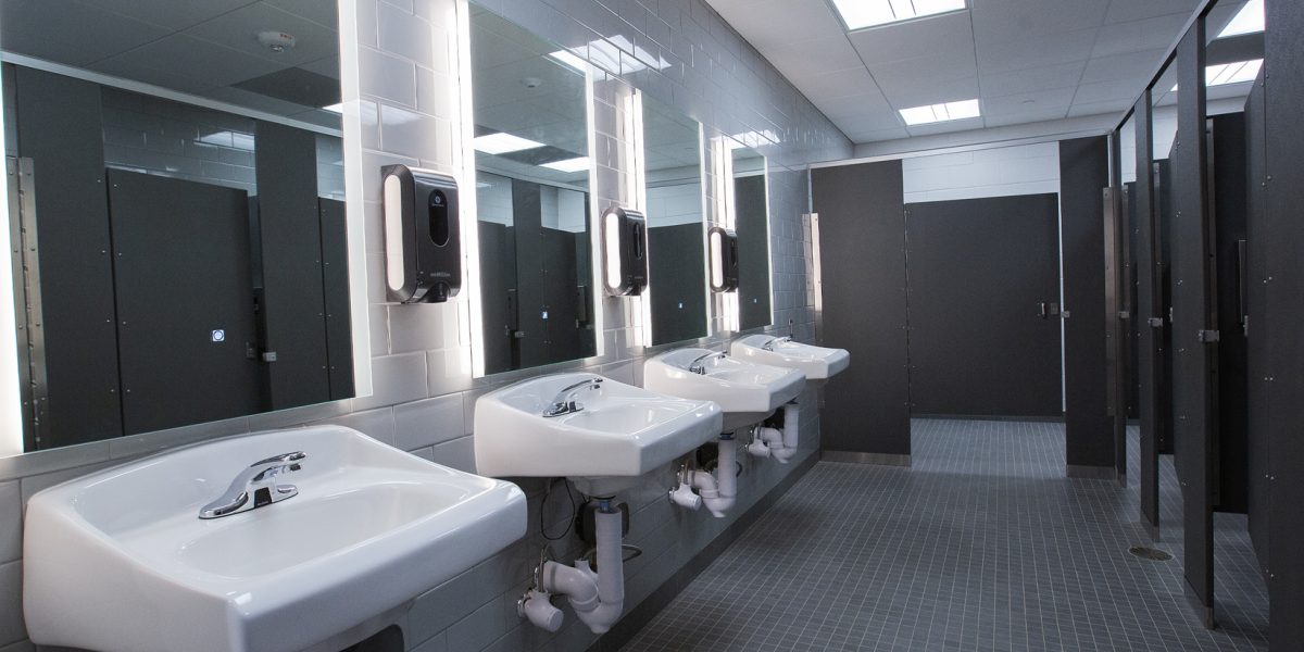 Backlit LED mirrors and integrated lighting in the NCSSM Morganton Wellness Center restrooms by Fountain Electric.